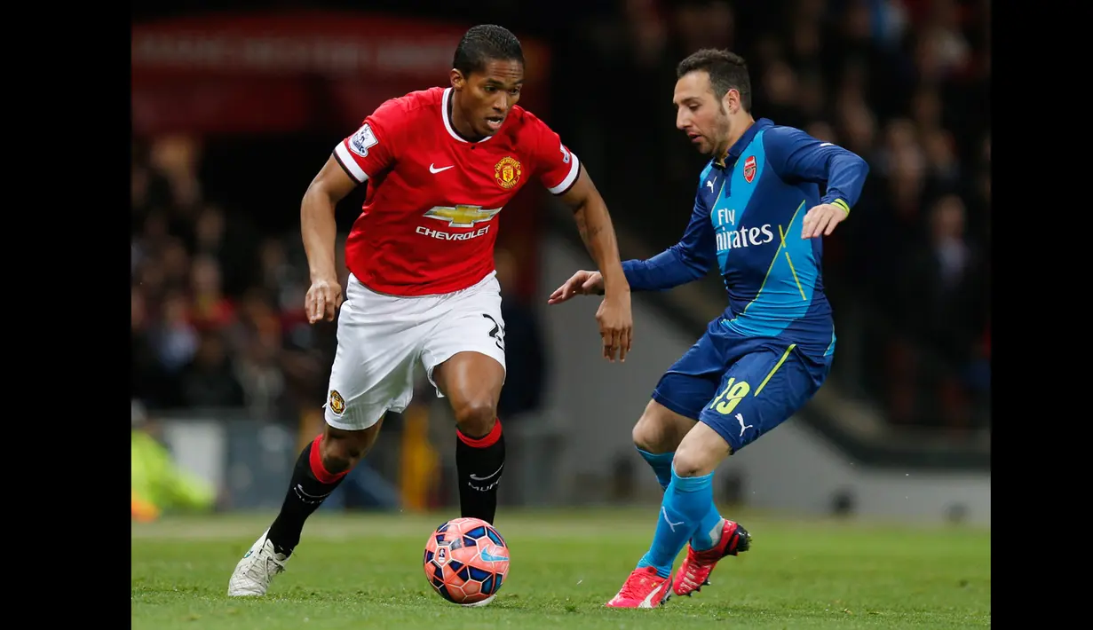 Gelandang Manchester,  Antonio Valencia berusaha membawa bola melewati pemain Arsenal Santi Carzola saat laga perempat final Piala FA di Stadion Old Trafford, Inggris (10/3/2015). Arsenal Menang 2-1 atas Manchester United. (Reuters/Jason Cairnduff)