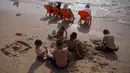 Anak-anak bermain pasir saat menghabiskan libur Idul Fitri di pantai Tel Aviv, Israel, Sabtu (16/6). (AP Photo/Oded Balilty)