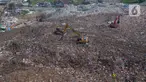 Alat berat eskavator  meratakan gunungan sampah di tempat Pembuangan Sampah Akhir (TPA) Burangkeng, Bekasi, Jawa Barat, Senin (6/5/2024). TPA Burangkeng rencananya akan memperluas lahan pembuangan sampah. (merdeka.com/Imam Buhori)