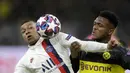 Penyerang PSG, Kylian Mbappe berebut bola dengan bek Dortmund, Dan-Axel Zagadou pada pertandingan leg pertama babak 16 Liga Champions di Dortmund, Jerman (18/2/2020). Dortmund menang 2-0 atas PSG. (AP Photo/Michael Probst)