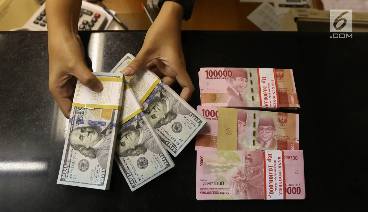 Pekerja menunjukan mata uang Rupiah dan Dolar AS di Jakarta, Rabu (19/6/2019). Nilai tukar rupiah terhadap dolar Amerika Serikat (AS) sore ini Rabu (19/6) ditutup menguat sebesar Rp 14.269 per dolar AS atau menguat 56,0 poin (0,39 persen) dari penutupan sebelumnya. (Liputan6.com/Angga Yuniar )