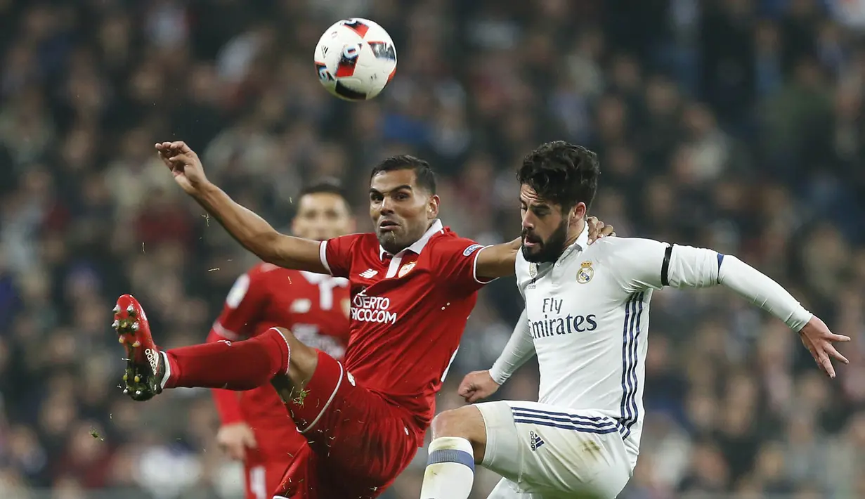 Gelandang Real Madrid, Isco, berusaha melewati bek Sevilla, Gabriel Mercado. Leg kedua akan berlangsung di Stadion Ramos Sanchez Pizjuan, Sevilla pada Kamis (12/1/2017). (AP/Stringer)