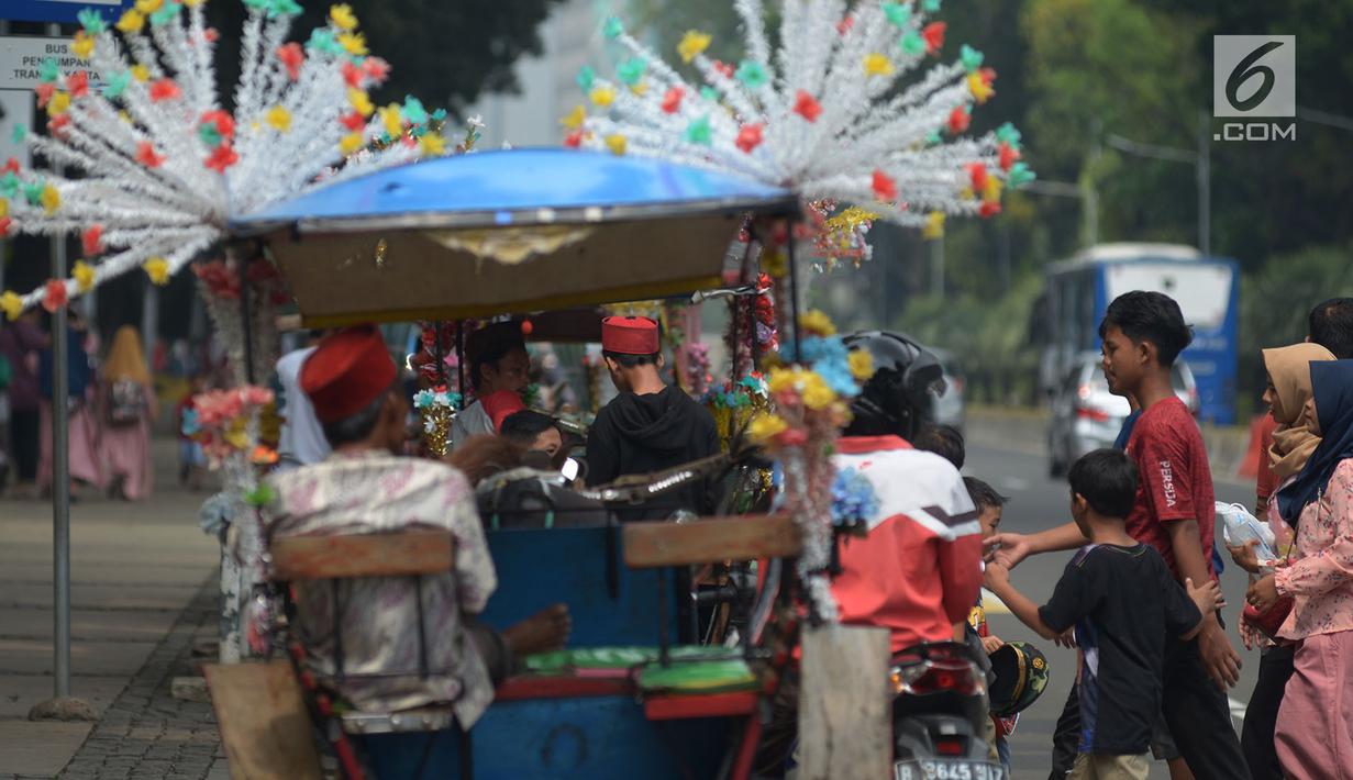 Pengunjung bersiap menaiki delman hias di Monumen Nasional (Monas), Jakarta, Sabtu (15/6/2019). Sebelumnya delman hias tersebut dilarang kini beroperasi kembali, delman tersebut mengenakan tarif pada pengunjung bervariasi untuk berkeliling di luar IRTI Monas. (merdeka.com/Imam Buhori)