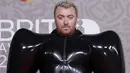 Sam Smith berpose untuk fotografer setibanya pada karpet merah Brit Awards 2023 di London, Sabtu (11/2/2023). Pelantun ‘Unholy’ ini memakai gaun unik berwarna hitam, lengkap dengan sepatu heels dan sarung tangan berwarna senada. (Photo by Vianney Le Caer/Invision/AP)