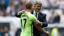 Senyum Manuel Pellegrini saat memeluk gelandang Kevin De Bruyne usai pertandingan di Stadion Liberty, Inggris (15/5). Pellegrini sukses mengantarkan Manchester City ke posisi empat dan merebut tiket liga Champions. (Reuters / Peter Cziborra)