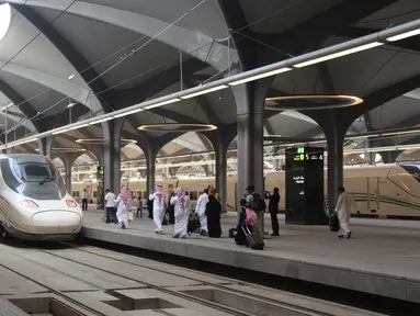 Para penumpang berjalan di peron ketika kereta api kecepatan tinggi Haramain resmi beroperasi di stasiun kereta Makkah, Kamis (11/10). Pengoperasian perdana kereta Haramain membawa jamaah dan musafir lainnya dari Makkah ke Madinah. (BANDAR ALDANDANI/AFP)
