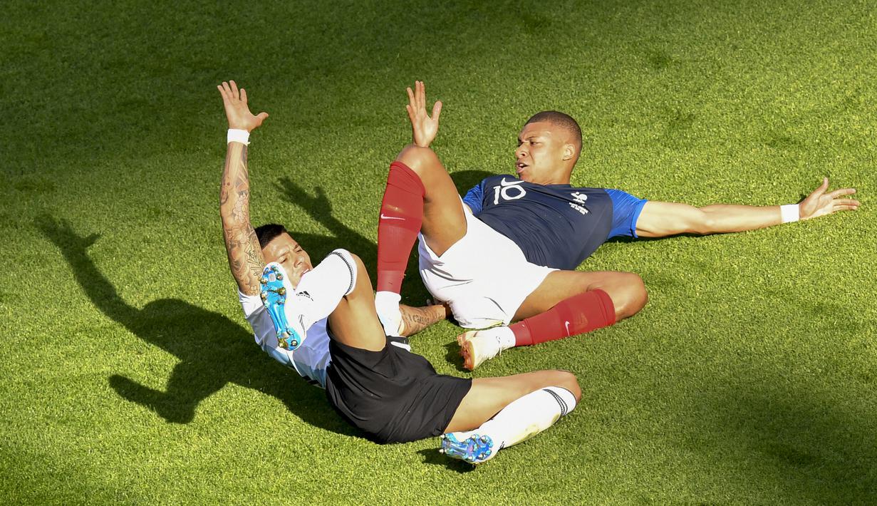 Bek Argentina, Marcos Rojo, menjatuhkan striker Prancis, Kylian Mbappe, pada laga 16 besar Piala Dunia di Kazan Arena, Kazan, Sabtu (30/6/2018). Prancis menang 4-3 atas Argentina. (AFP/Franck Fife)