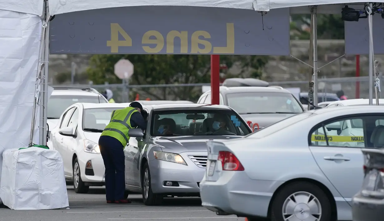 Petugas melayani tenaga kesehatan yang berada di dalam mobil di pusat vaksinasi drive-thru di City College of San Francisco di San Francisco, Senin (1/2/2021). Ketika pasokan vaksin COVID-19 meningkat, UCSF memperluas upaya vaksinasi kepada mereka yang paling berisiko. (AP Photo/Jeff Chiu)