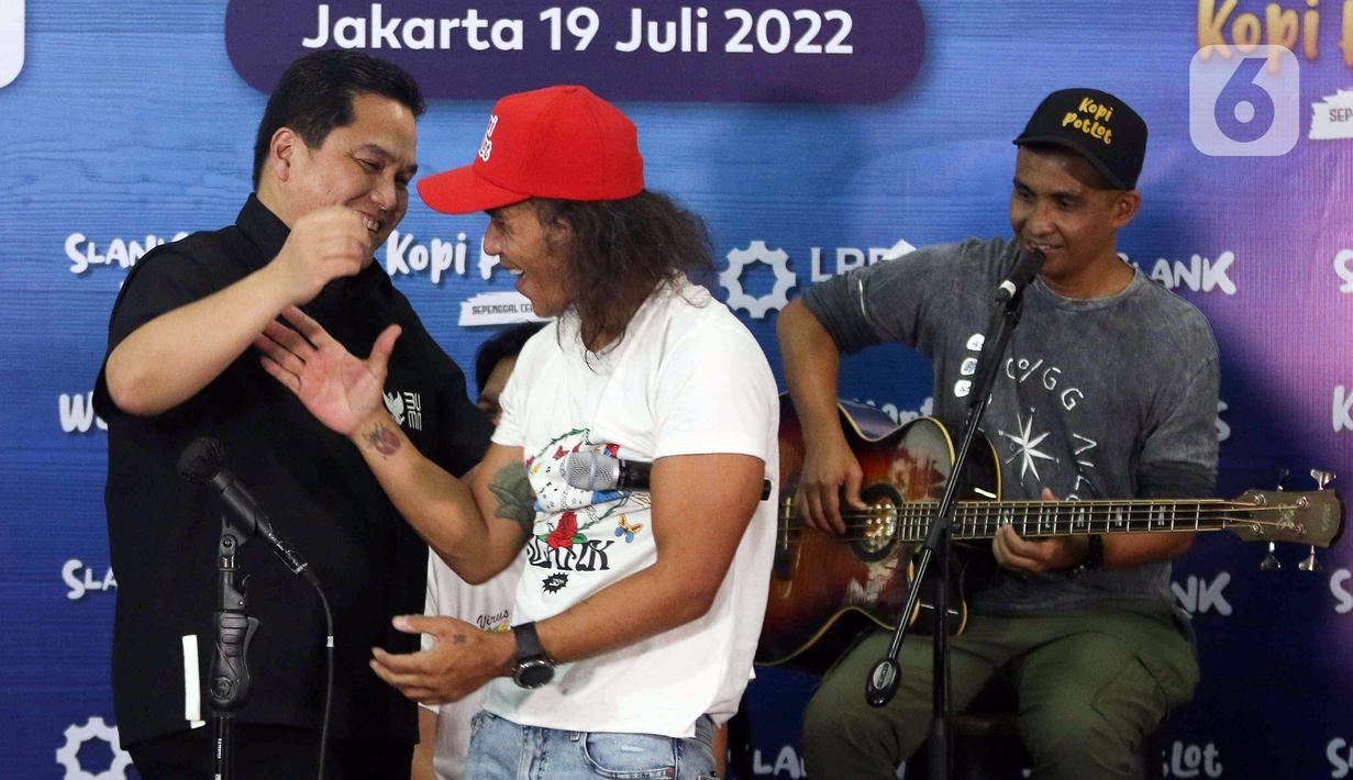 Grup band Slank bernyanyi bersama Menteri BUMN Erick Thohir (kiri) usai peluncuran Slankops di Basecamp Slank, Jakarta, Selasa (19/7/2022). Slank bersama Menteri BUMN Erick Thohir dan Menteri Koperasi dan UKM Teten Masduki bernyanyi bersama membawakan lagu 'Ku Tak Bisa' dan 'Balikin'. (Liputan6.com/Herman Zakharia)