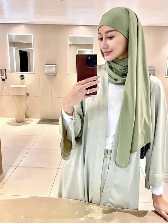 Ia juga mengenakan pashmina warna hijau dipadukan two pieces warna serasi dengan inner putihnya. [Instagram/@ayumaulida97]