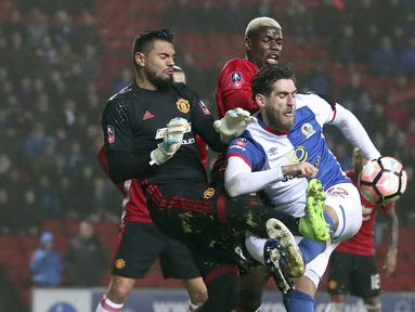 Pemain Blackburn Rovers, Danny Graham (kanan) berebut melepaskan tembakan saat dihadang kiper Manchester United, Sergio Romero dan Paul Pogba pada putaran kelima Piala FA di Ewood Park, Blackburn, (19/2/2017). (Martin Rickett/PA via AP)
