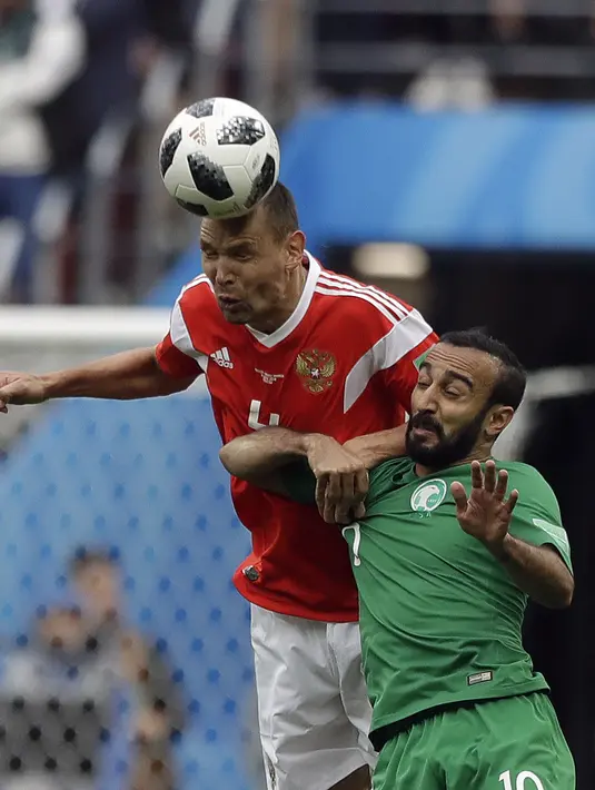 Duel pemain Rusia, Sergei Ignashevich (kiri) dan pemain Arab Saudi, Mohammed Alsahlawi pada laga grup A Piala Dunia 2018 di Luzhniki stadium, Moskow, Rusia, (14/6/2018). Rusia menang 5-0. (AP/Matthias Schrader)