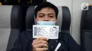 Penumpang Kereta Bandara Premium menunjukkan tiket saat menanti keberangkatan di Stasiun Manggarai, Jakarta, Sabtu (3/4/2021). PT Railink meluncurkan kereta bandara kelas premium dengan harga tiket lebih terjangkau. (merdeka.com/Imam Buhori)