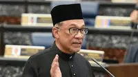 Ketua Partai Keadilan Rakyat Malaysia, Anwar Ibrahim mengucapkan sumpah jabatan dalam upacara pelantikan di Gedung Parlemen, Kuala Lumpur, Senin (15/10). Anwar Ibrahim dilantik sebagai anggota parlemen setelah memenangkan pemilu sela. (MOHD RASFAN/AFP)