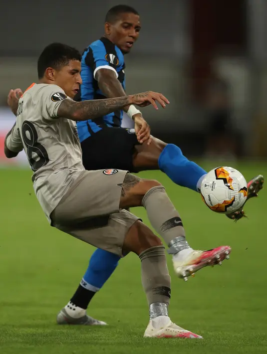 Pemain Shakhtar Donetsk, Dodo berebut bola dengan pemain sayap Inter Milan, Ashley Young pada pertandingan semifinal Liga Europa di Dusseldorf Arena, Senin (17/8/2020). Bungkam Shakhtar Donetsk 5-0, Inter Milan tantang Sevilla di final Liga Europa musim 2019/20. (Lars Baron/Pool Photo via AP)