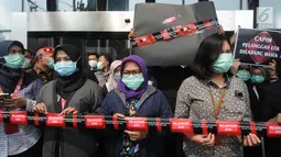 Pegawai KPK membentangkan garis line bertuliskan 'Dilarang Melewati Batas Pelanggar Etik' saat aksi di Lobi Gedung KPK, Jakarta, Jumat (6/9/2019). Dalam aksinya, mereka menolak Capim KPK jilid V yang dianggap bermasalah dan rencana pengesahan RUU KPK. (merdeka.com/Dwi Narwoko)