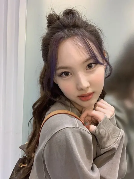 Nayeon mewarnai rambut panjangnya menjadi cokelat. Menariknya, poninya diwarnai dengan ungu. Gaya rambut ponytail setengah rambut yang acak. Instagram @twicetagram