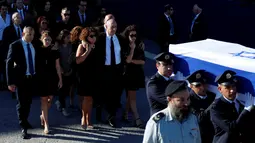 Anggota keluarga mantan Presiden Israel, Shimon Peres berjalan di belakang peti jenazah Shimon Peres saat upacara pemakaman di Knesset, Israel, Jumat (30/9). Rencananya Shimon Peres akan dimakamkan di ke Gunung Herzl Cemetery. (REUTERS/ Ammar Awad)
