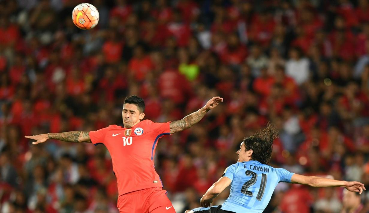 Pemain Cile, Pedro Hernandez (kiri), berduel dengan striker Uruguay, Edinson Cavani, pada laga Kualifikasi Piala Dunia 2018 zona CONMEBOL di Stadion Nasional Julio Martinez Pradanos, Santiago, Rabu (16/11/2016) pagi WIB. (AFP/Martin Bernetti)