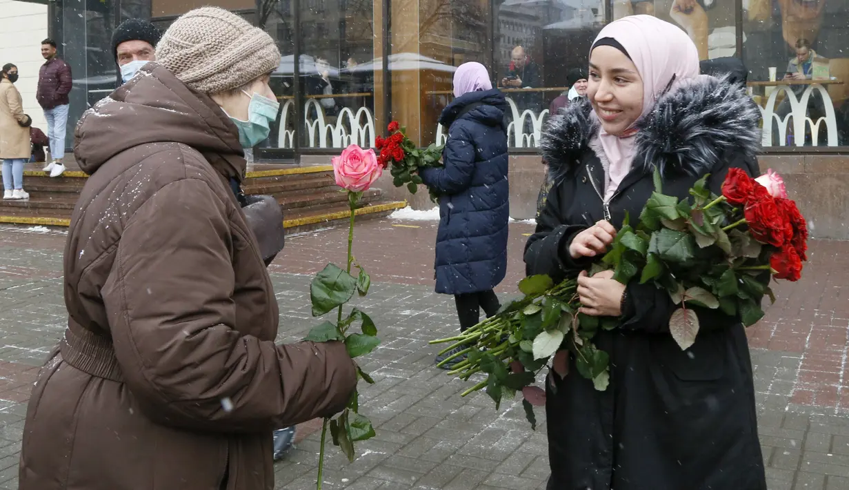 Seorang aktivis berhijab memberikan bunga kepada seorang perempuan pejalan kaki untuk memperingati World Hijab Day atau Hari Hijab Sedunia di Kyiv, Ukraina, Senin (1/2/2021). Hari Hijab Sedunia merupakan gagasan Nazma Khan di New York, Amerika Serikat pada tahun 2013. (AP Photo/Efrem Lukatsky)