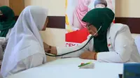 Tim dokter Unilever Indonesia cek kesehatan santriwati dalam penanaman Pola Hidup Bersih dan Sehat (PHBS) pada 300 santri di PPTQ Al Hikmah Semarang. Foto: Liputan6.com/ Felek Wahyu