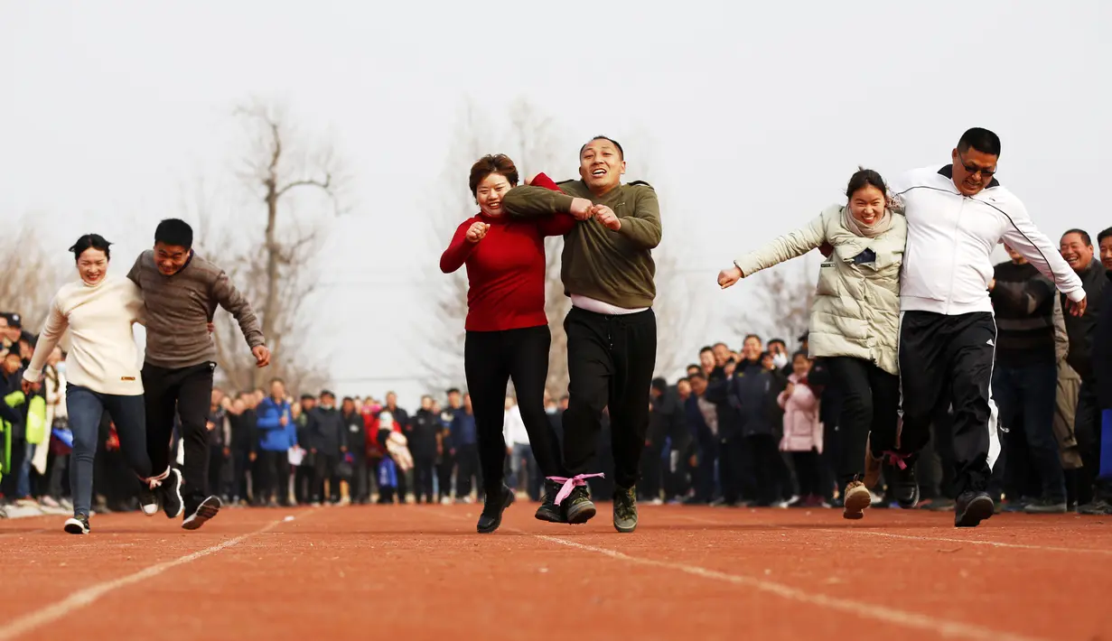 Para petani berpartisipasi dalam perlombaan kaki tiga di Yaogou, Sihong, Suqian, Provinsi Jiangsu, China, 27 Desember 2020. Rangkaian perlombaan seru diadakan setiap tahun sejak 2018 di Yaogou menjelang Tahun Baru. (Xinhua/Xu Changliang)