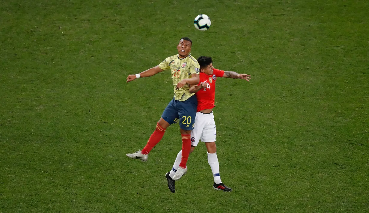 Pemain  Kolombia, Roger Martinez berebut bola dengan gelandang timnas Cile, Esteban Pavez pada perempat final Copa America 2019 di Arena Corinthians, Jumat (29/6/2019). Cile melaju ke semifinal Copa America 2019 setelah menundukkan Kolombia, 5-4, lewat adu penalti. (AP/Nelson Antoine)