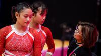 Pesenam putri Indonesia, Salsabilla Hadi Pamungkas (kiri) dan Alarice Mallica Prakoso mendengarkan instruksi dari pelatih Eva Novalina Butarbutar saat Kejuaraan Dunia Gimnastik 2025 di Indonesia Arena, Senayan, Jakarta, Selasa (21/10/2025). (Bola.com/Bagaskara Lazuardi)
