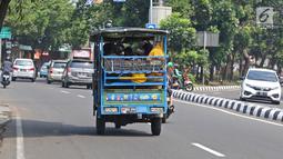 Sejumlah warga menaiki bak terbuka motor roda tiga menuju Kebun Binatang Ragunan di kawasan Jakarta, Minggu (9/6/2019). Masyarakat memanfaatkan motor roda tiga untuk bepergian saat libur lebaran karena dianggap lebih hemat biaya. (Liputan6.com/Herman Zakharia)