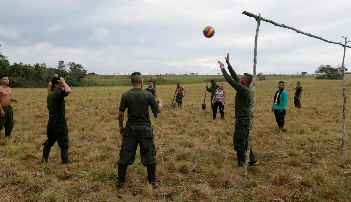 Para pejuang dari Angkatan Bersenjata Revolusioner Kolombia (FARC) bermain voli di sebuah kamp dimana mereka mempersiapkan diri untuk pengesahan kesepakatan damai dengan pemerintah, di Yari Plains, Kolombia, (17/9). (REUTERS/John Vizcaino)