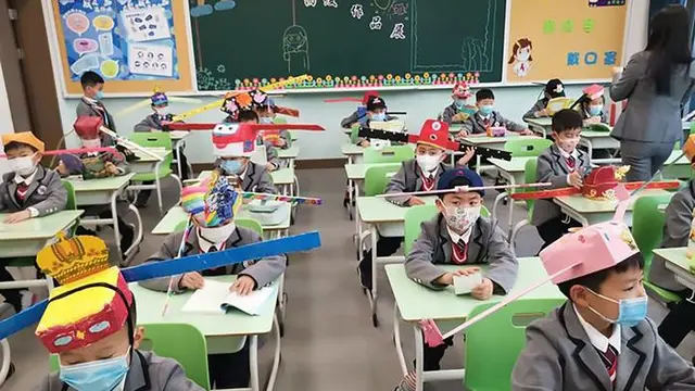 Terapkan Physical Distancing, Murid di China Ini Kenakan Topi Anti Corona