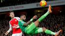 Pemain Arsenal, Mesut Ozil (kiri) melihat gelandang Sunderland, Yann M'vila, saat menendang salto dalam laga Liga Inggris di Stadion Emirates, London, (5/12/2015). (AFP/IKIMAGES/Ian Kington) 