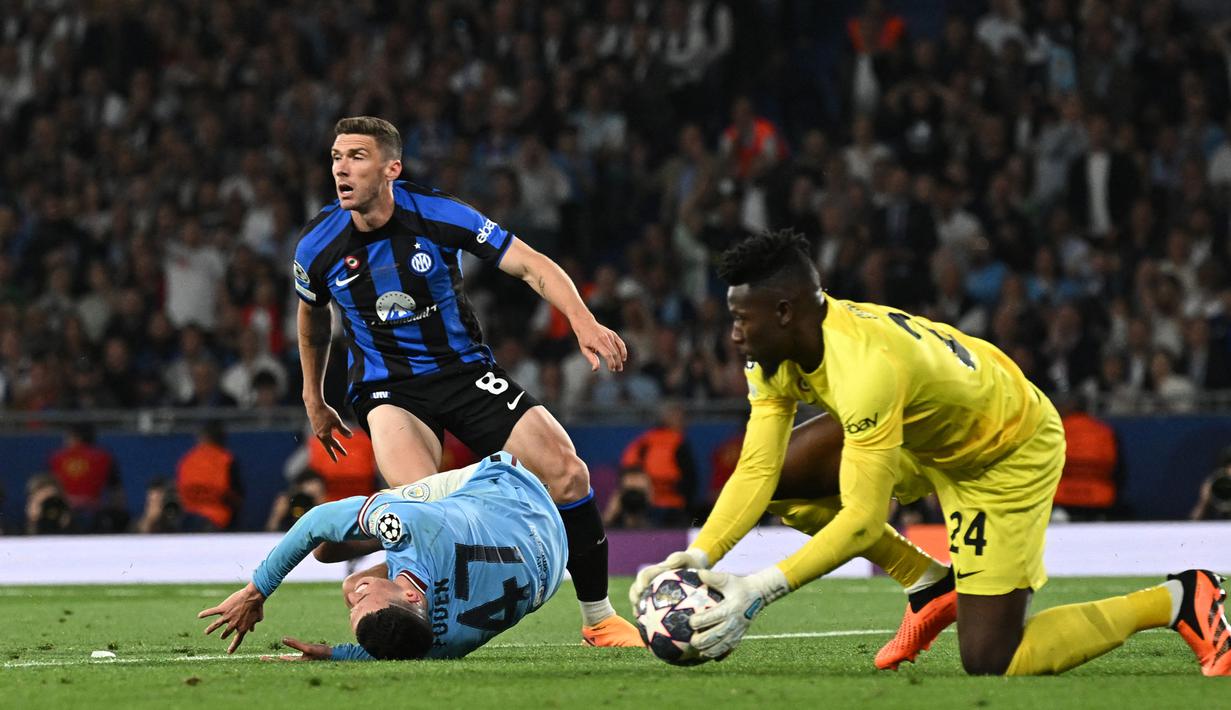 Kiper Inter Milan, Andre Onana (kanan) menangkap bola hasil tembakan gelandang Manchester City, Phil Foden pada laga final Liga Champions 2022/2023 di Ataturk Olympic Stadium, Istanbul (10/6/2023). Keseriusan Manchester United untuk mendatangkan Andre Onana dari Inter Milan terlihat dengan kesiapan Setan Merah mengeluarkan dana mencapai 50 juta poundsterling. (AFP/Paul Ellis)