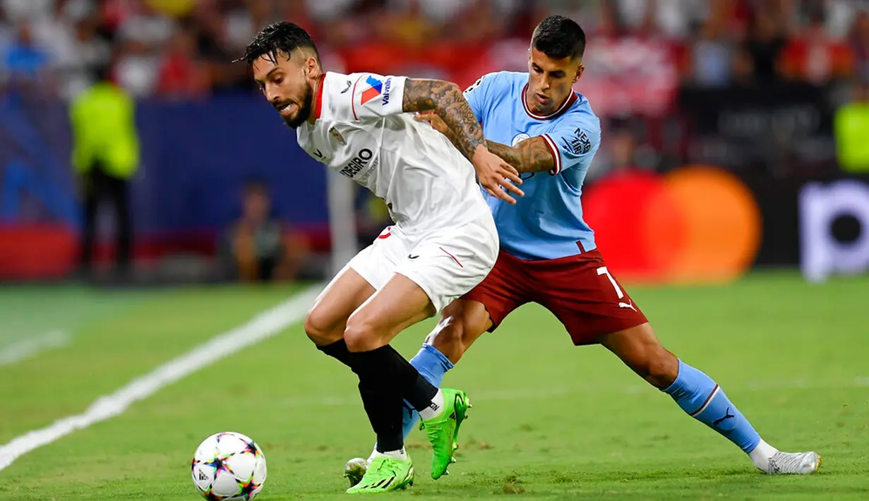 Pemain Sevilla Alex Telles berebut bola dengan pemain Manchester City Joao Cancelo (kanan) pada pertandingan sepak bola grup G Liga Champions di Seville, Spanyol, 6 September 2022. Manchester City menang 4-0. (AP Photo/Jose Breton)