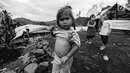 Seorang anak perempuan Suku Baduy Luar dengan menarik bajunya pose di lokasi bekas kebakaran Kampung Cisaban II, Desa Kanekes, Banten, Kamis (01/6). Kebakaran pada pekan lalu yang menghanguskan 83 rumah Suku Baduy Luar. (Liputan6.com/Fery Pradolo)