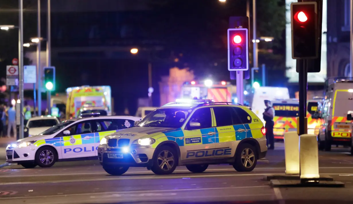Kendaraan polisi terlihat di lokasi serangan teror dekat kawasan London Bridge, Sabtu (3/6). Setelah sebuah van menabrak pejalan kaki di Jembatan London, aksi penusukan juga terjadi di sebuah kafe tak jauh dari tempat tersebut. (AP Photo/ Matt Dunham)