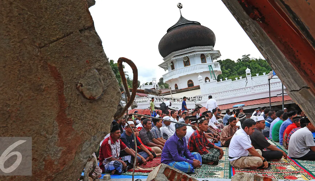 Warga memanfaatkan halaman Masjid Jami Quba untuk melaksanakan Salat Jumat, Aceh, Jumat (9/12). Gempa berkekuatan 6,5 SR telah merobohkan ratusan bangunan termasuk Masjid Jami Quba. (Liputan6.com/Angga Yuniar)