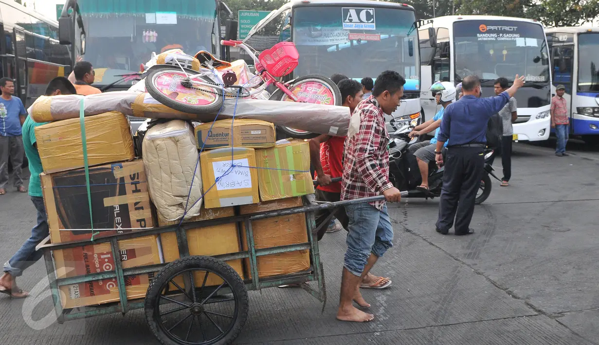 Dua orang pria sedang menarik gerobak berisi barang penumpang di terminal Pulogadung, Jakarta, Jumat (10/7/15). Terminal Polugadung memberangkatkan sebanyak 521 penumpang dan bus yang diberangkatkan sekitar 118 bus. (Liputan6.com/Herman Zakharia)