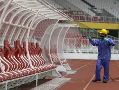 Petugas menyemprotkan cairan disinfektan ke bench pemain di Stadion Utama Gelora Bung Karno (SUGBK), Jakarta, Kamis (26/3/2020). Penyemprotan dilakukan guna mencegah penyebaran virus corona COVID-19 di seluruh venue kawasan SUGBK. (merdeka.com/Imam Buhori)