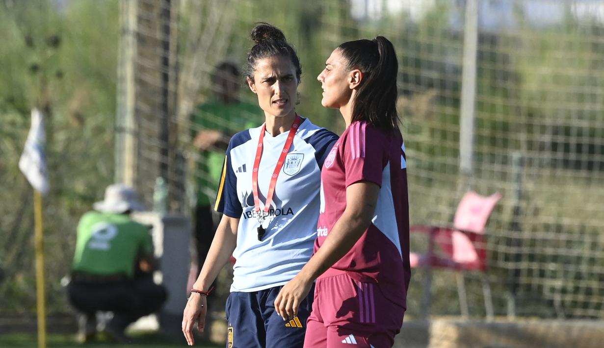 Pelatih kepala Timnas Wanita Spanyol, Montse Tome (kiri) berbincang dengan Cristina Martin-Prieto saat berlatih menjelang laga UEFA Nations League melawan Swedia di Oliva, Spanyol pada Rabu (20/09/2023) waktu setempat. Pelatih Montse Tome ditunjuk untuk menggantikan Jorge Vilda yang mundur dari jabatannya. (AFP/Jose Jordan)