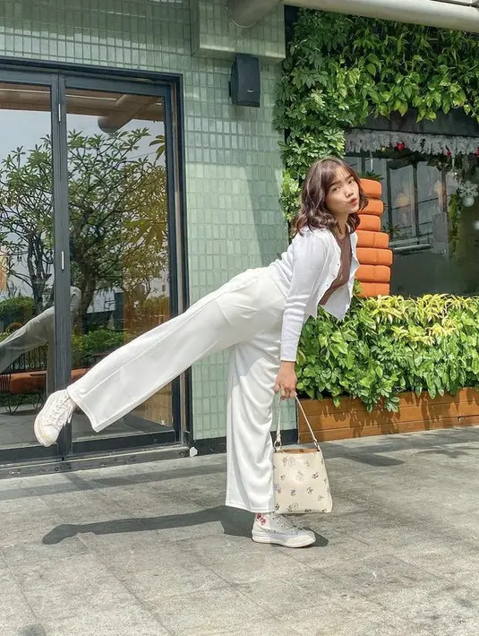 Fuji tampil casual dengan pakaian serba putih, loose pants dipadukan cardigan dan inner tshirt cokelat. Dikombinasikan sepatu high dan sling bag warna senada dari Coach seharga Rp6.4 jutaan. (Instagram @fuji_an)
