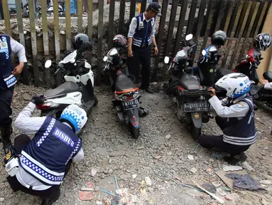Petugas Dishub mencabut pentil kendaraan roda dua dalam operasi penertiban parkir liar di Pusat, Jumat (23/10/2015). Meskipun informasi penertiban diduga telah bocor, ratusan kendaraan yang parkir liar tetap ditertibkan. (Liputan6.com/Immanuel Antonius)