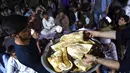 Panitia membagikan makan berbuka puasa kepada umat muslim di sebuah masjid di Kabul, Afganistan, 16 Juni 2016. Tradisi berbuka puasa bersama selama Ramadan merupakan momentum untuk mempererat tali persaudaraan. (Wakil Kohsar/AFP)