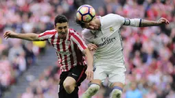 Penyerang Athletic Bilbao, Aritz Aduriz, duel udara dengan bek Real Madrid, Sergio Ramos. Berdasarkan statistik, Madrid mencatatkan 48 persen penguasaan bola berbanding 52 persen milik Bilbao. (AFP/Ander Gillenea)