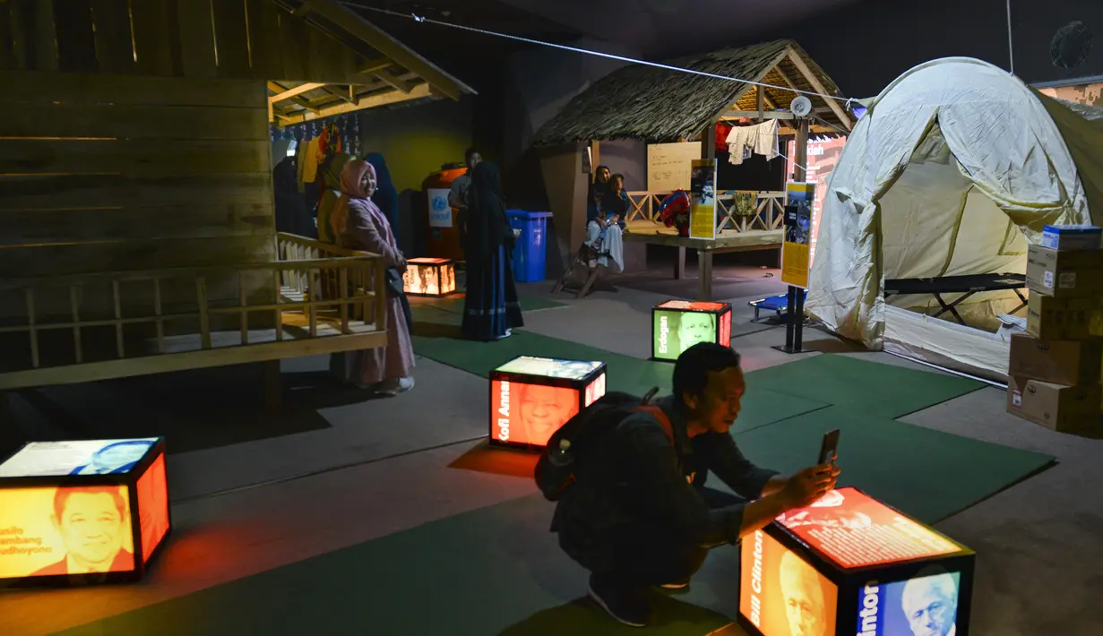 Pengunjung melihat pameran yang menggambarkan tempat perlindungan sementara di Museum Tsunami Aceh di Banda Aceh (19/10/2019). Museum ini berfungsi sebagai pengingat gempa bumi dan tsunami Samudra Hindia 2004. (AFP Photo/Chaideer Mahyuddin)