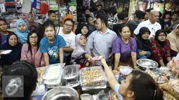 Sejumlah calon pembeli mengantre membeli kue kering di Pasar Jatinegara, Jakarta, Senin (27/6). Warga lebih memilih untuk membeli kue kering siap saji daripada membuat kue sendiri. (Liputan6.com/Faizal Fanani)