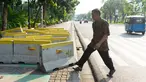 Pejalan kaki menghindari pembatas jalan yang menutupi trotoar di Jalan Medan Merdeka Utara, Jakarta, Rabu (3/7/2019). Pembatas jalan yang berada tidak pada tempatnya tersebut mengganggu pejalan kaki karena menutupi badan trotoar. (Liputan6.com/Immanuel Antonius)