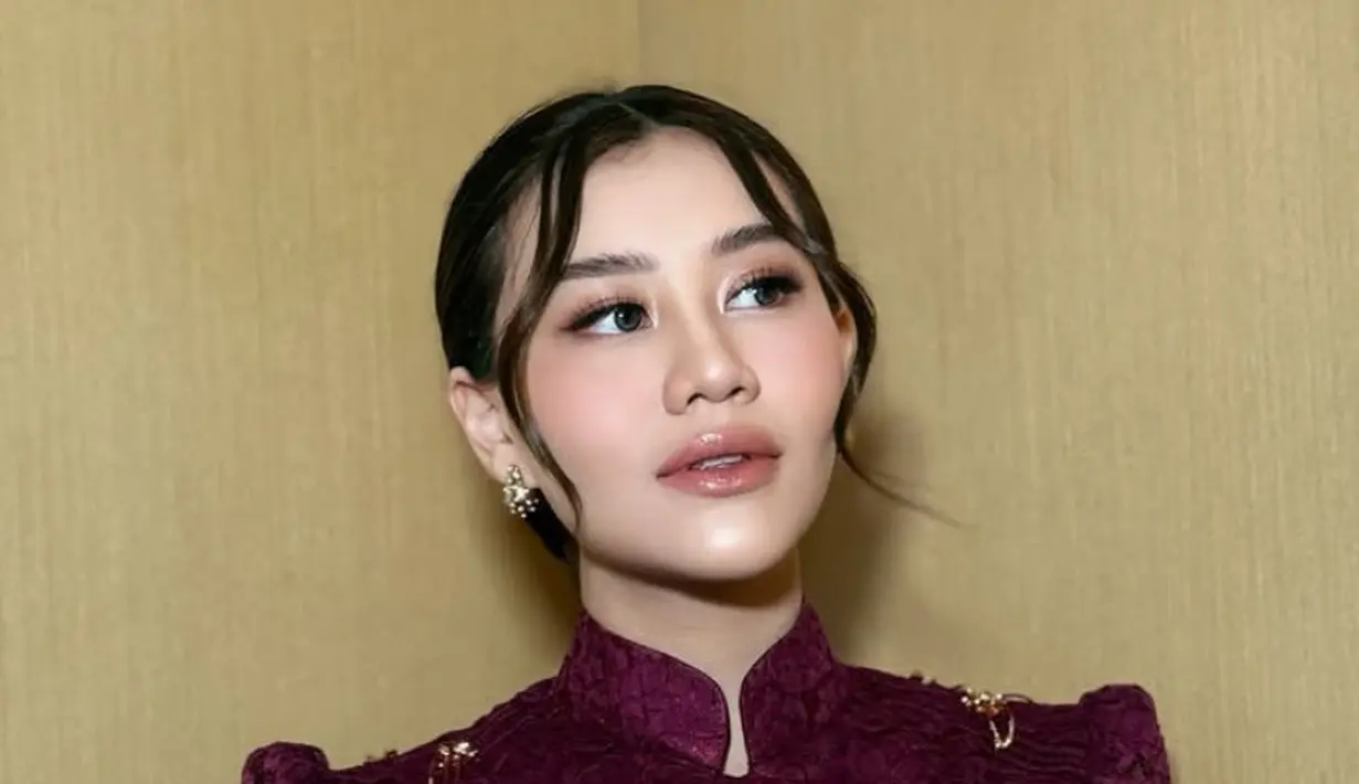 Matanya pun dirias dengan eye shadow coral shimmer serta eyeliner wings tipis. Bulu matanya tampak rapi. [@ochiipramita]