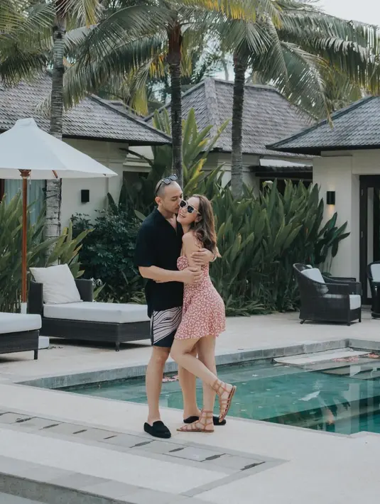 Foto gemas BCL dan Tiko saat bulan madu setelah menikah. BCL tampil manis dengan summer dress bercorak floral merah, sedangkan Tiko dengan kemeja hitam lengan pendek dan celana pendek serasi. [Foto: Instagram/itsmebcl]