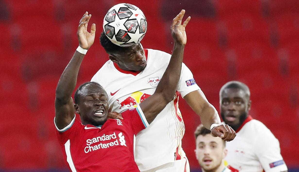Pemain RB Leipzig, Nordi Mukiele, duel udara dengan penyerang Liverpool, Sadio Mane, pada laga Liga Champions di Puskas Arena, Kamis (11/3/2021). Liverpool menang dengan skor 2-0. (AP/Laszlo Balogh)